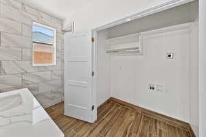 Laundry area featuring wood finish floors, electric dryer hookup, and washer hookup