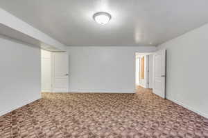 Spare room featuring a textured ceiling and carpet floors