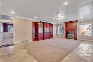 Unfurnished living room with crown molding, a fireplace, and recessed lighting