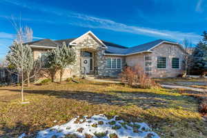 Ranch-style home featuring a front lawn and brick siding