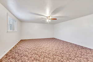 Spare room with carpet floors and a ceiling fan