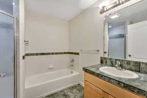 Bathroom with vanity, a garden tub, and a shower stall