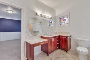 Bathroom featuring vanity, light carpet, and wainscoting