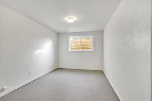 Empty room with finished concrete floors and baseboards