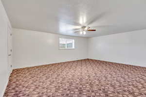 Unfurnished room with carpet floors, ceiling fan, and a textured ceiling