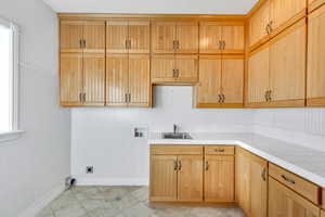 Laundry area with hookup for a washing machine, cabinet space, electric dryer hookup, and light tile patterned flooring