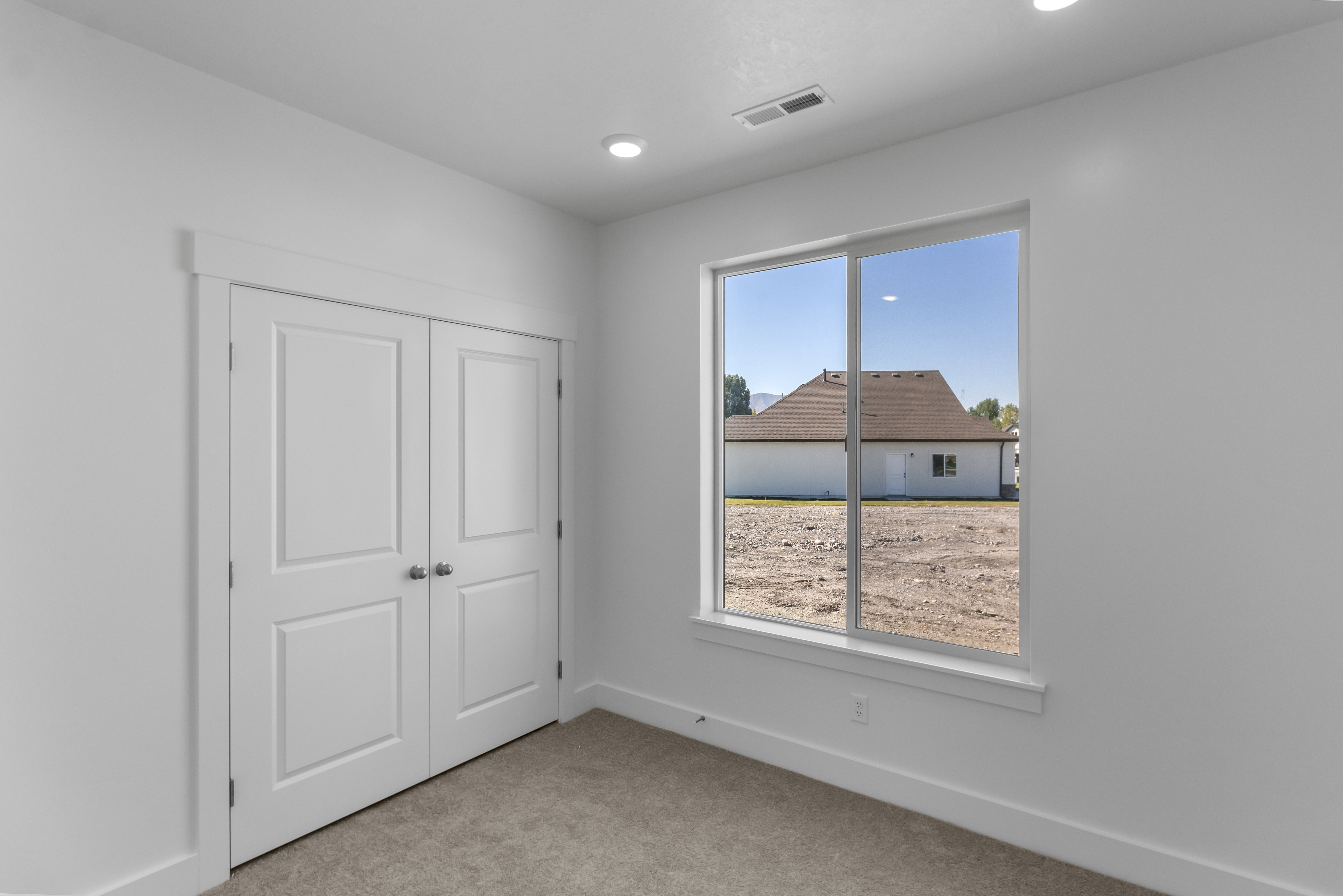 Unfurnished bedroom with light carpet and a closet