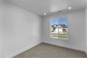Carpeted spare room featuring baseboards and recessed lighting