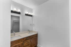 Bathroom with double vanity and a spacious closet