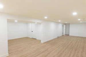 Finished below grade area featuring recessed lighting and light wood-style floors