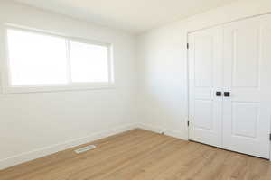 Unfurnished bedroom with light wood-style flooring and a closet