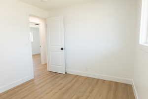 Empty room with light wood-style floors and baseboards