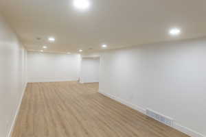 Finished below grade area featuring light wood finished floors and recessed lighting