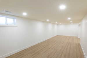 Below grade area featuring light wood-style flooring and recessed lighting