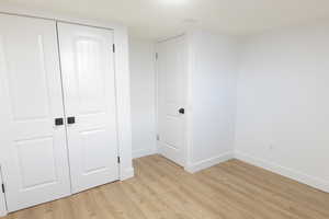 Unfurnished bedroom featuring light wood-style flooring and a closet