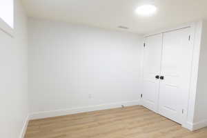 Unfurnished bedroom featuring light wood-style floors and a closet