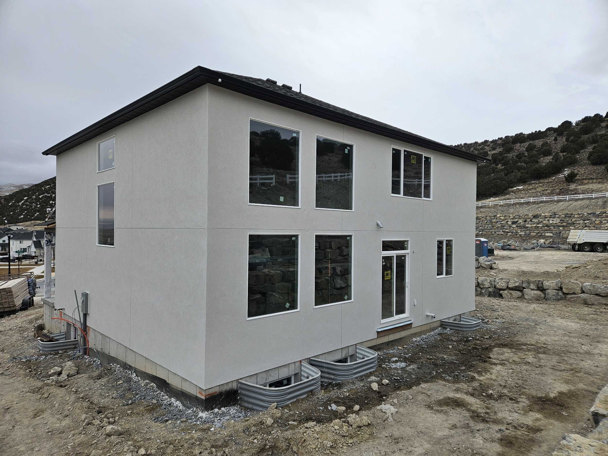 Rear view of house with a mountain view and stucco siding