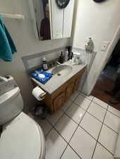 Bathroom with vanity, backsplash, and light tile patterned flooring