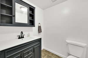 Half bathroom featuring vanity and stone finish flooring