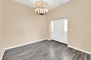 Foyer entrance featuring a chandelier and wood finished floors