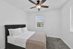 Bedroom with dark carpet and ceiling fan