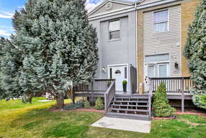 Rear view of property featuring a lawn and a deck
