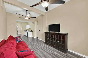 Living area with dark wood finished floors and a ceiling fan