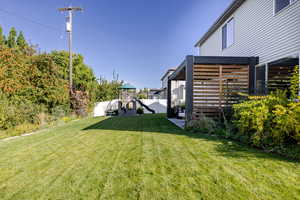 Fenced yard with a playground and a patio
