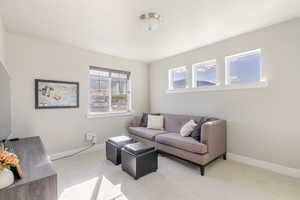 Carpeted living area with baseboards