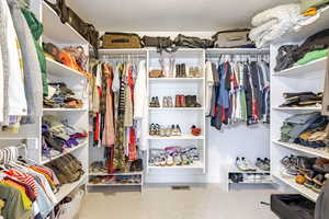Walk in closet with light colored carpet