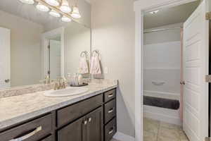 Full bathroom featuring vanity, light tile patterned flooring, and shower / bath combination
