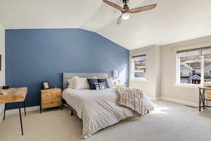 Carpeted bedroom featuring lofted ceiling and ceiling fan