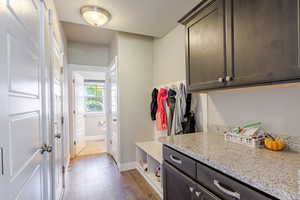 Mudroom featuring dark wood-type flooring and baseboards