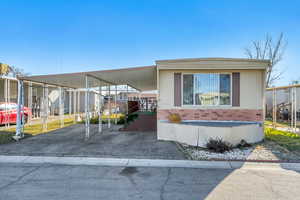 Manufactured / mobile home featuring a carport and driveway
