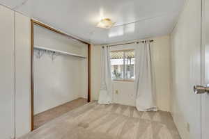 Unfurnished bedroom featuring a closet and carpet flooring