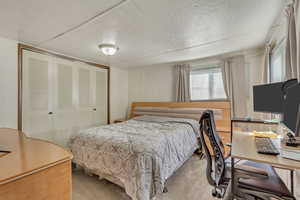 Bedroom with an office area, carpet floors, a closet, and wooden ceiling