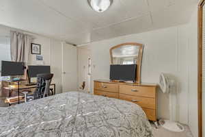 Bedroom featuring wood ceiling, an office area, carpet floors, and multiple windows