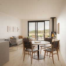 Dining space featuring light wood-type flooring, a wood stove, and a mountain view