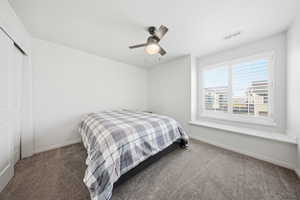Carpeted bedroom featuring a closet and ceiling fan