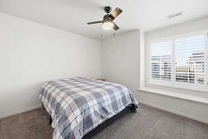 Carpeted bedroom featuring baseboards and a ceiling fan