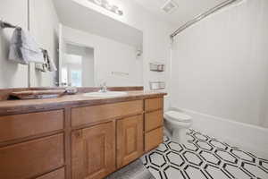Bathroom featuring vanity and shower / bath combination with curtain