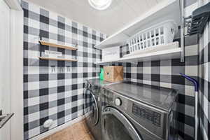 Laundry room featuring independent washer and dryer and light tile patterned floors