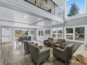Living room with hardwood / wood-style floors, a high ceiling, and recessed lighting