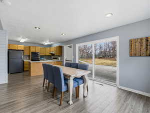 Dining space with dark wood-type flooring and recessed lighting