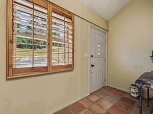 Foyer entrance with baseboards and lofted ceiling