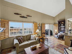 Tiled living area featuring lofted ceiling and a sink
