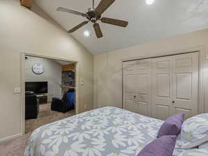 Carpeted bedroom with vaulted ceiling, ceiling fan, a closet, and recessed lighting