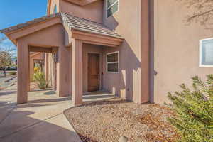Doorway to property with stucco siding and a tile roof