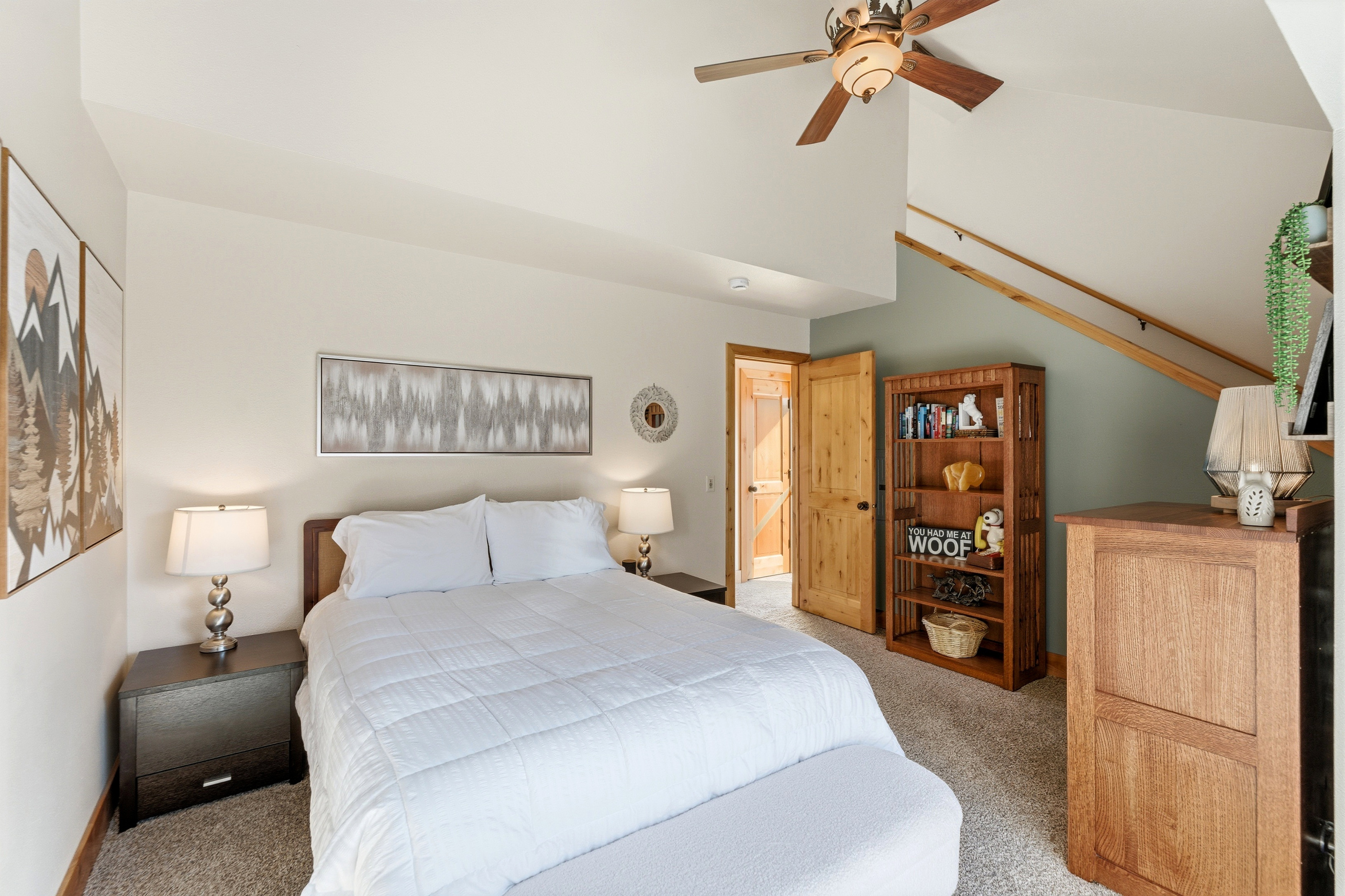 Carpeted bedroom with a ceiling fan and a high ceiling