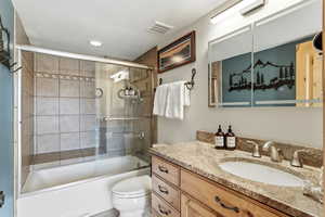 Full bath with vanity and bath / shower combo with glass door